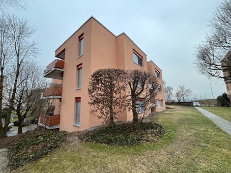 Modern 2-story apartment building, beige, large windows, balcony