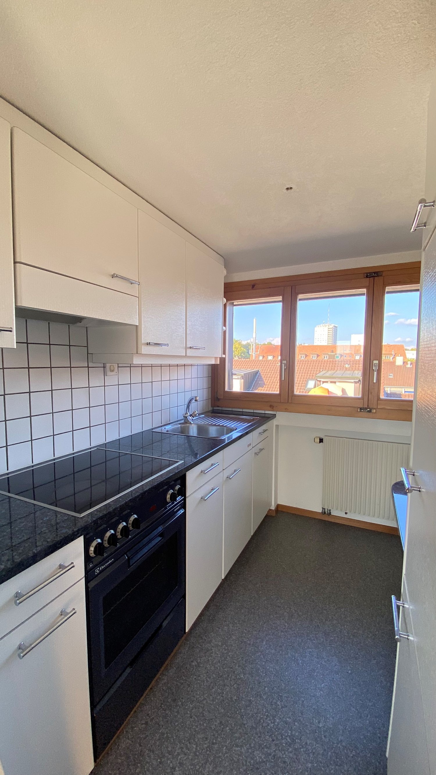 kitchen with oven, stove, sink, cabinets, radiator, windows