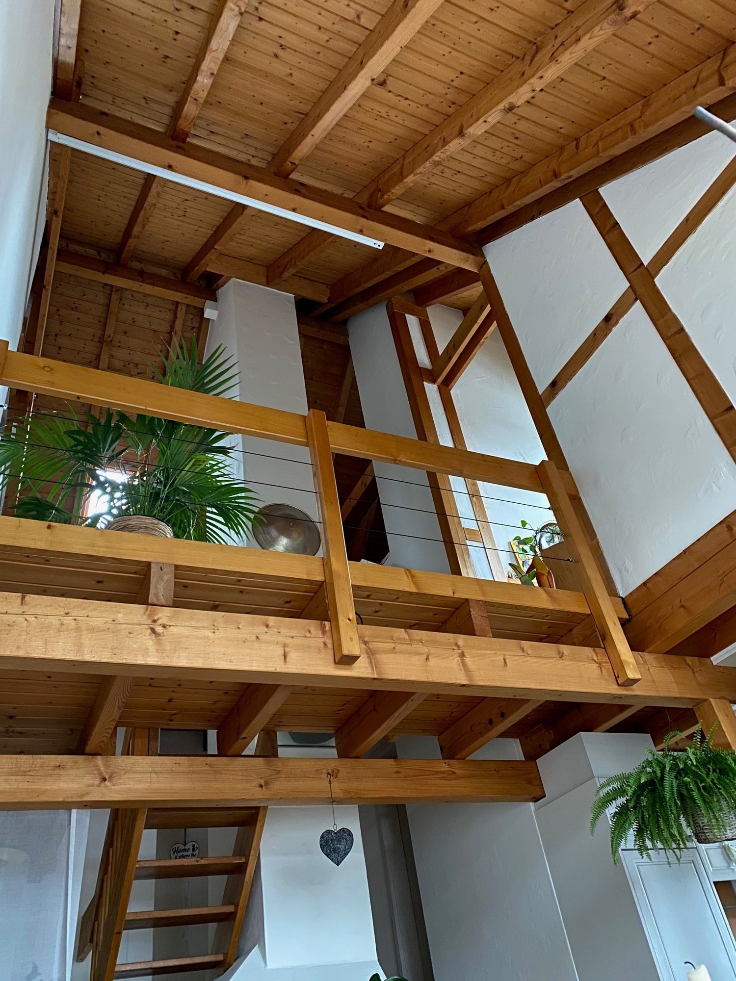 wooden ceiling, wooden floor, balcony with wooden railing and plants