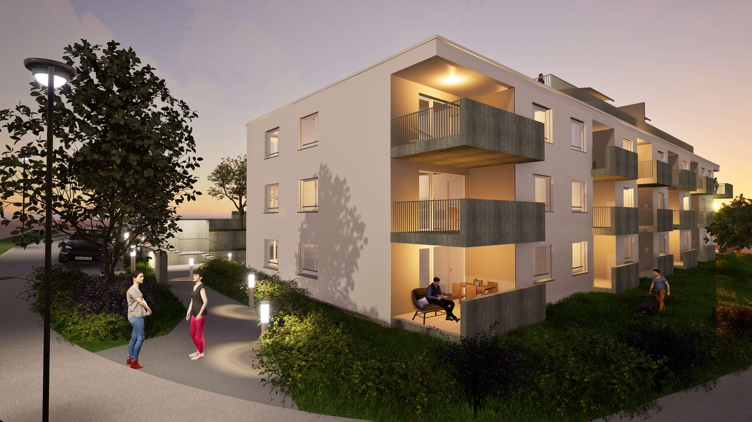 3-story modern apartment building with balconies, large windows, and outdoor lighting. The building has a contemporary design with a mix of concrete and glass elements. There are people visible in the image, walking along the path in front of the building