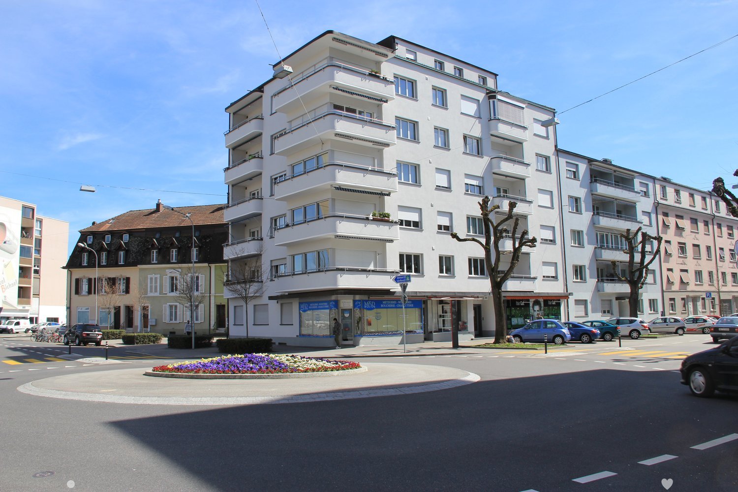 Apartment building, 6 stories, raised ground floor, balconies, storefronts on the ground floor