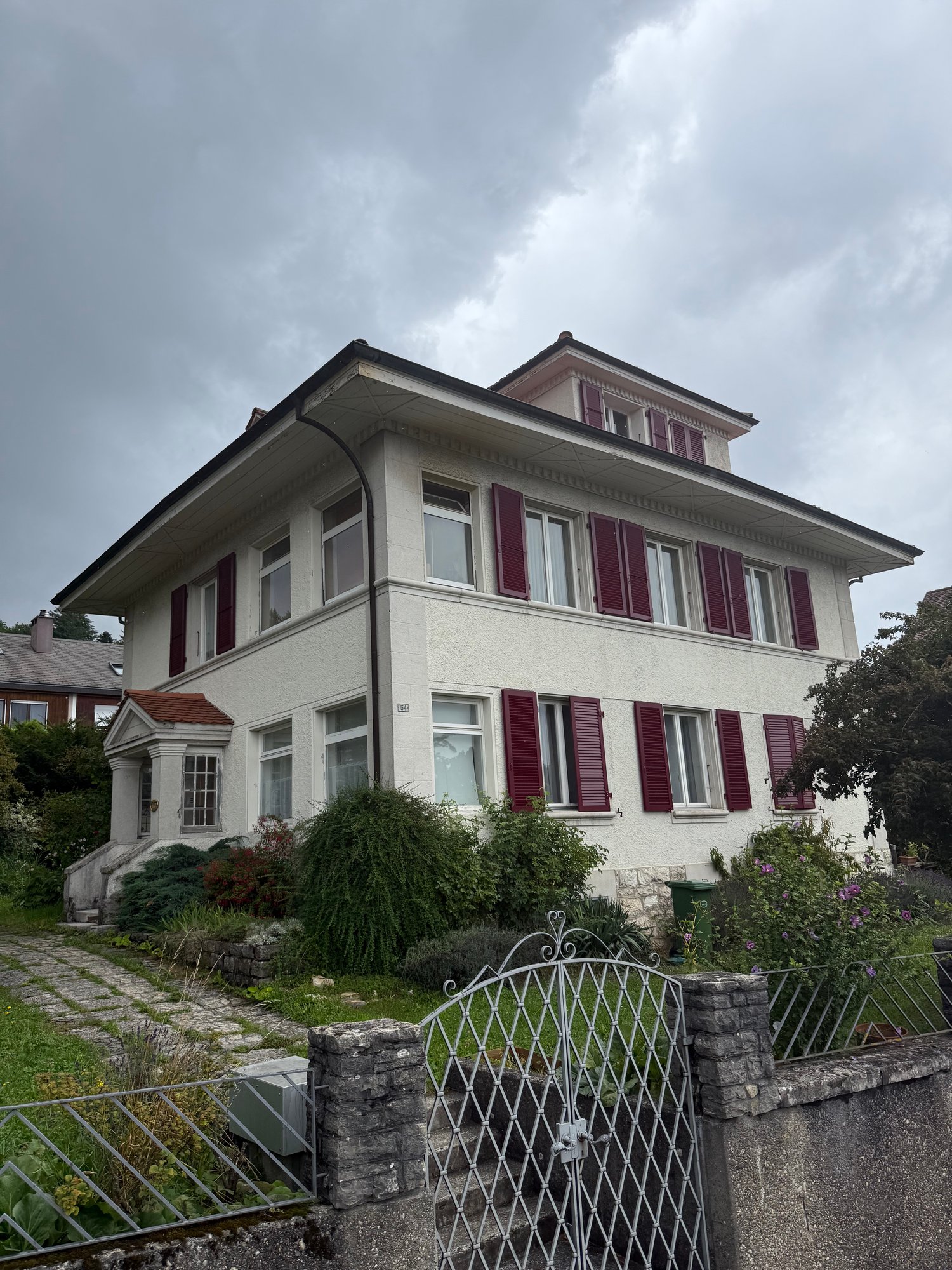 2 story house, white exterior, red shutters, garden, entrance gate