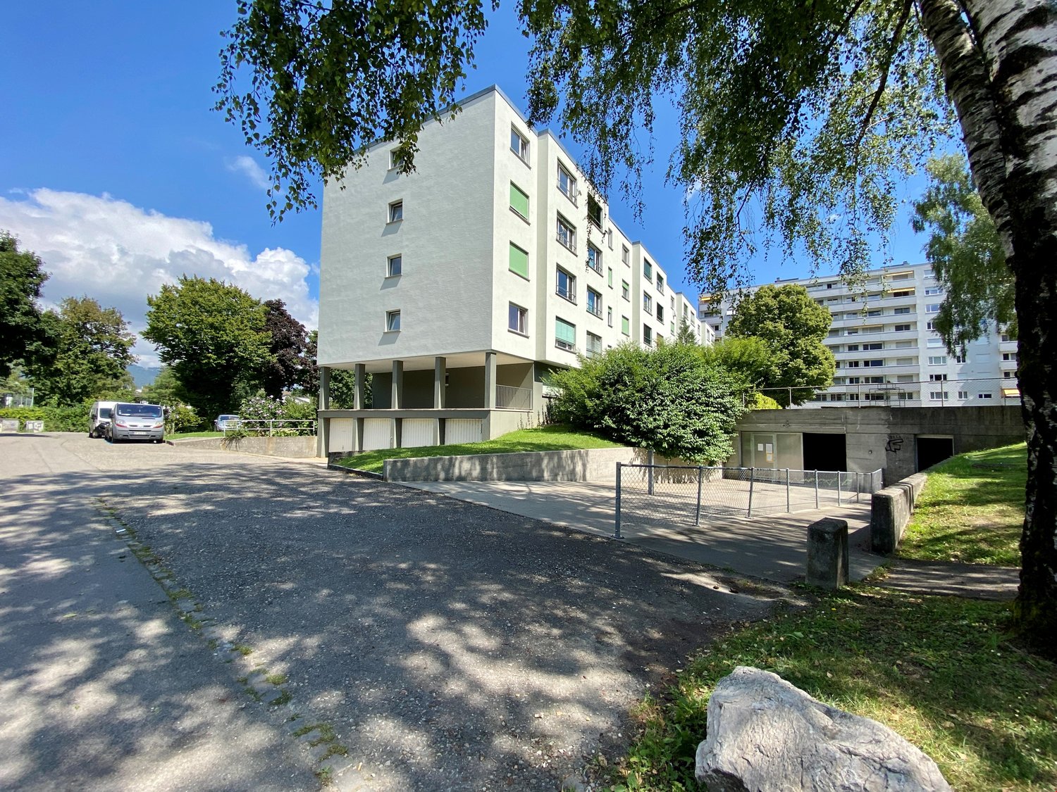 Residential building with several windows and a parking area at the front