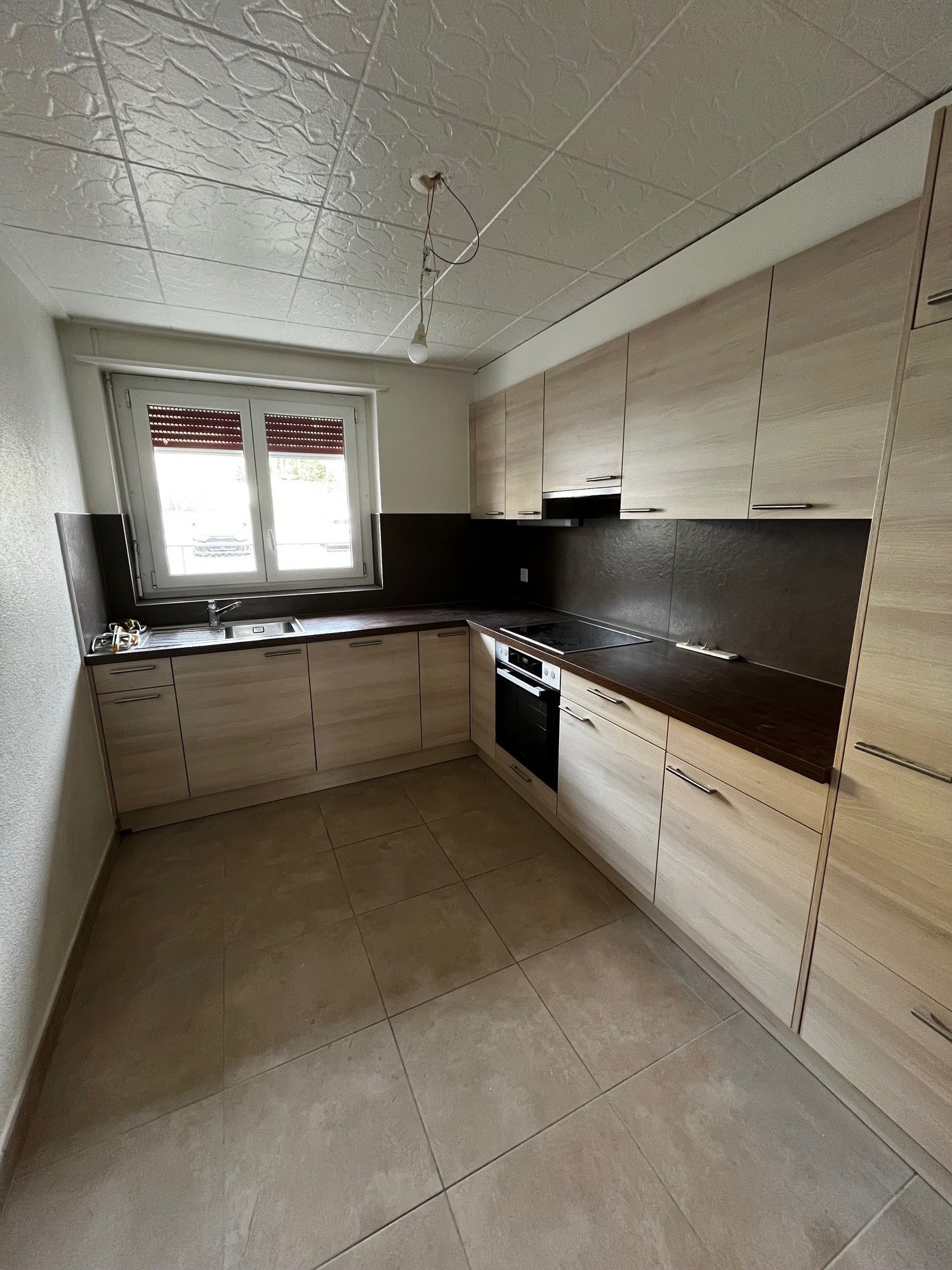 modern kitchen with wooden cabinets, tiled floor, sink, oven, dishwasher, window with blinds