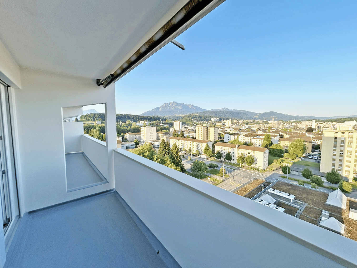 Balcony, modern apartment, large windows, city view, mountains in the distance