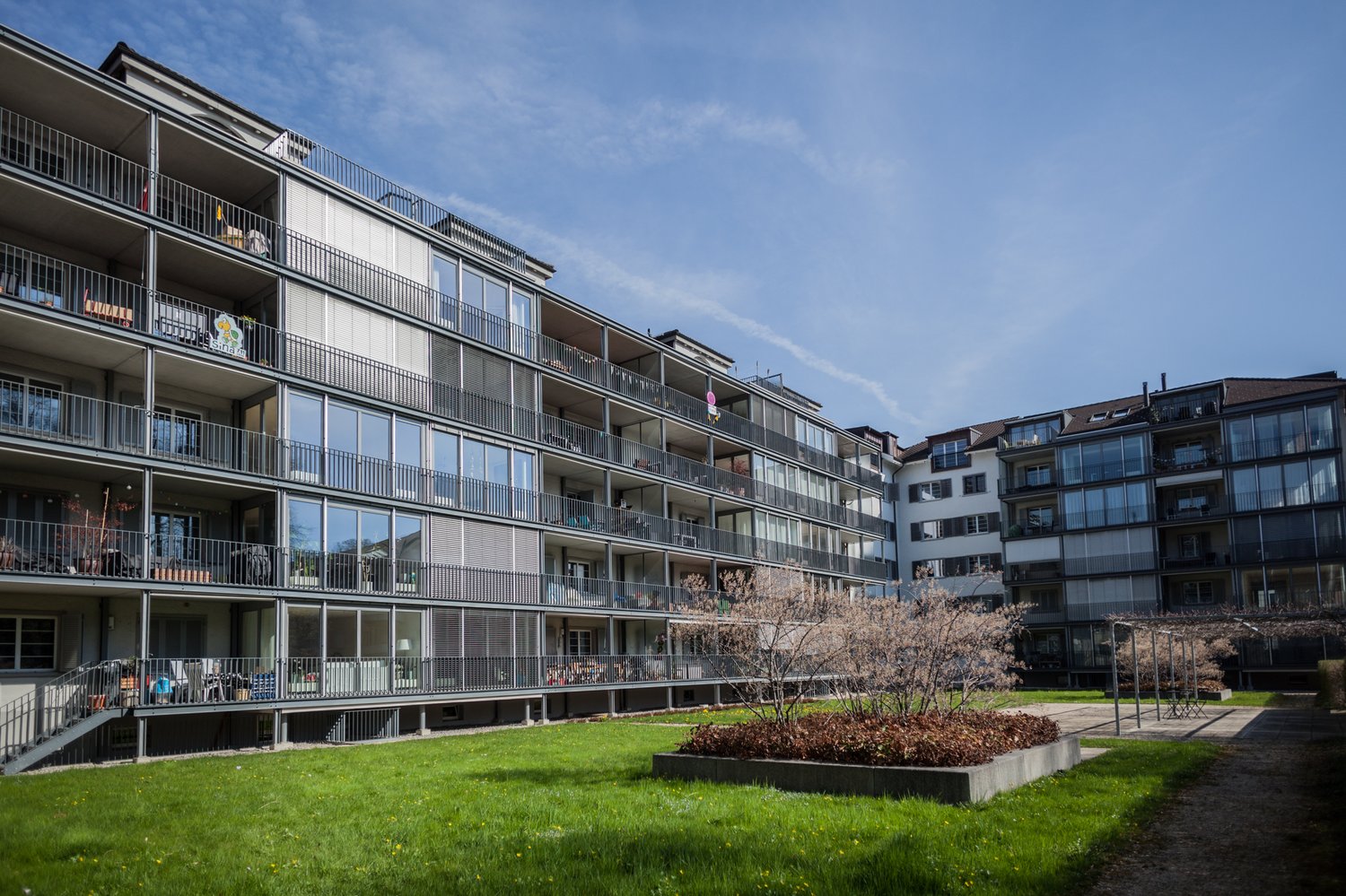6 story apartment building, balconies, large garden, lawn, shrubs