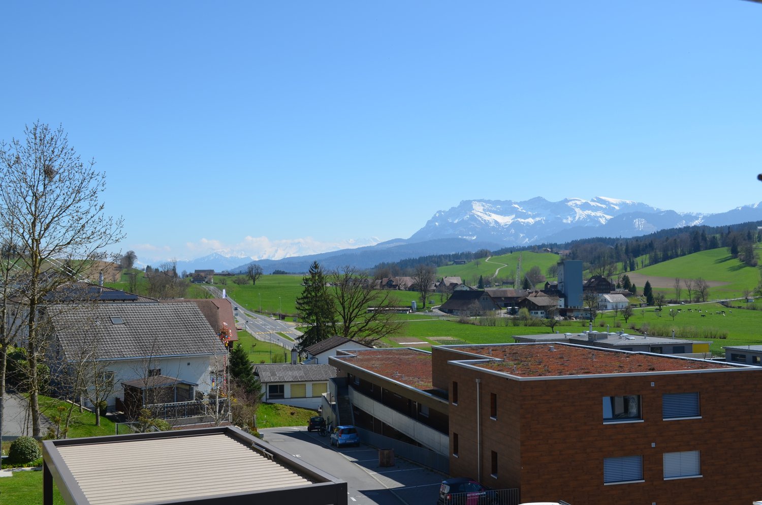 View of a building, residential houses and mountains in the background