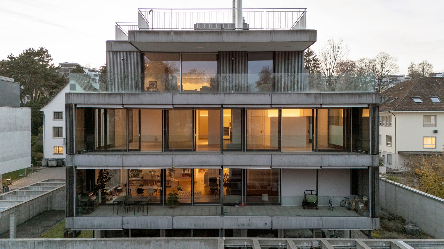 three story building with glass exterior, terraces on second and third floor