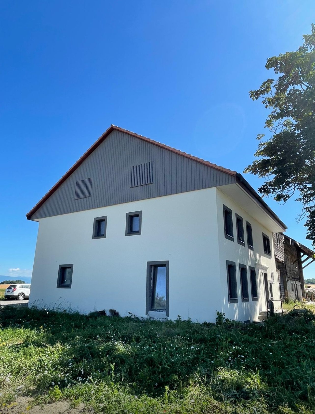 2 story house, white paint, gray roof, modern design, large windows, parked car
