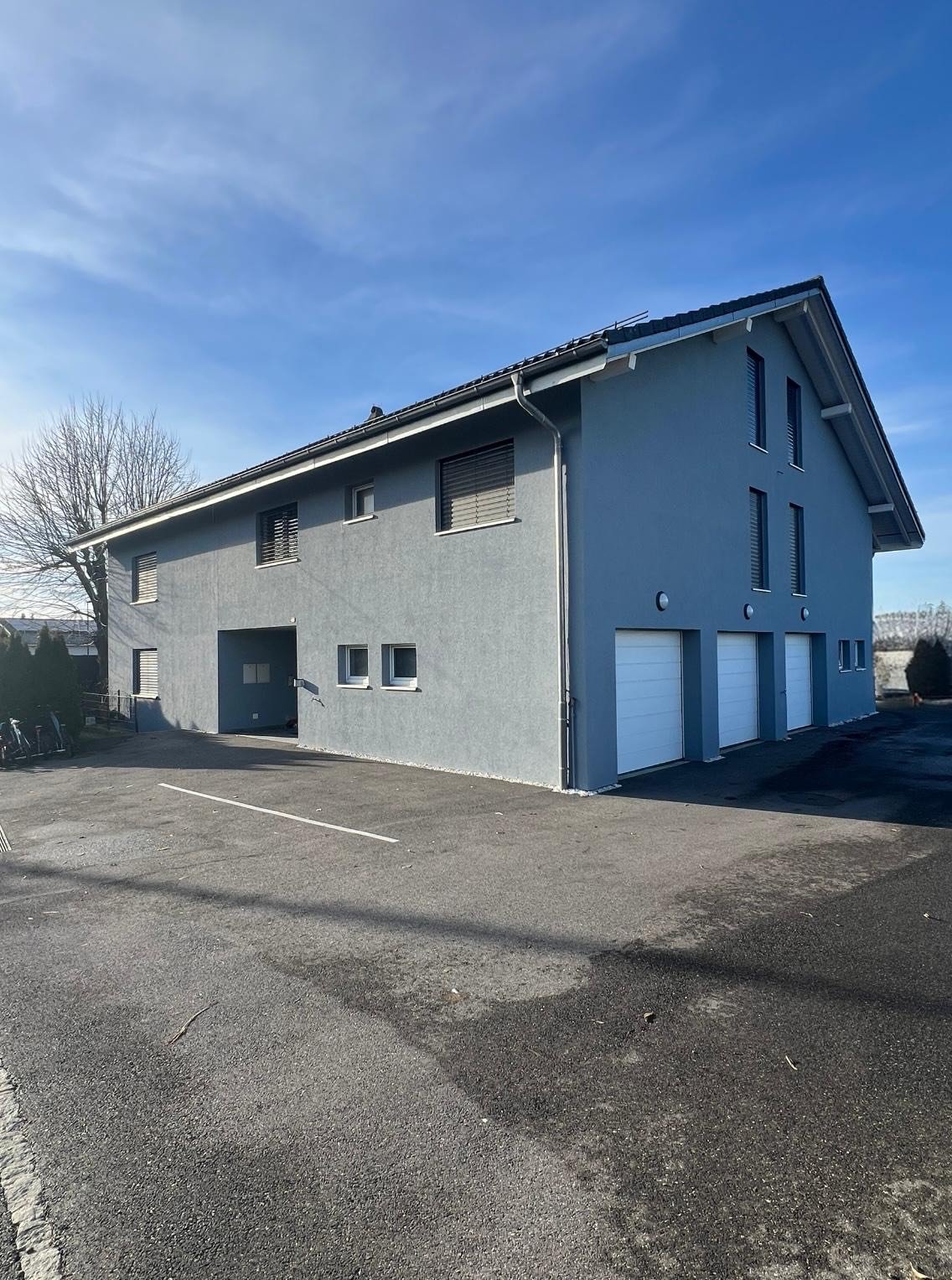 grey exterior, large windows, 3 garages, large parking space