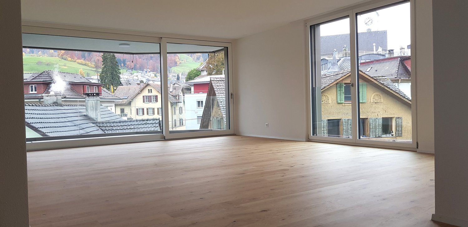 spacious room with large windows, hardwood floors, open balcony, scenic view