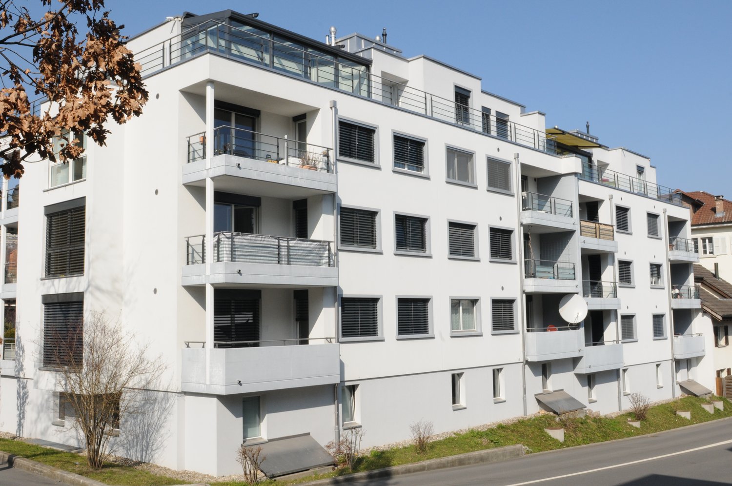 Apartment building, white exterior, balconies, multiple windows