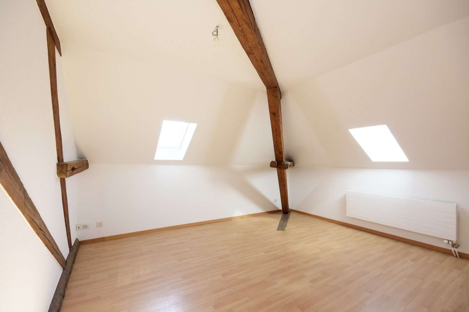 wooden beams, wooden flooring, windows, white walls, radiator