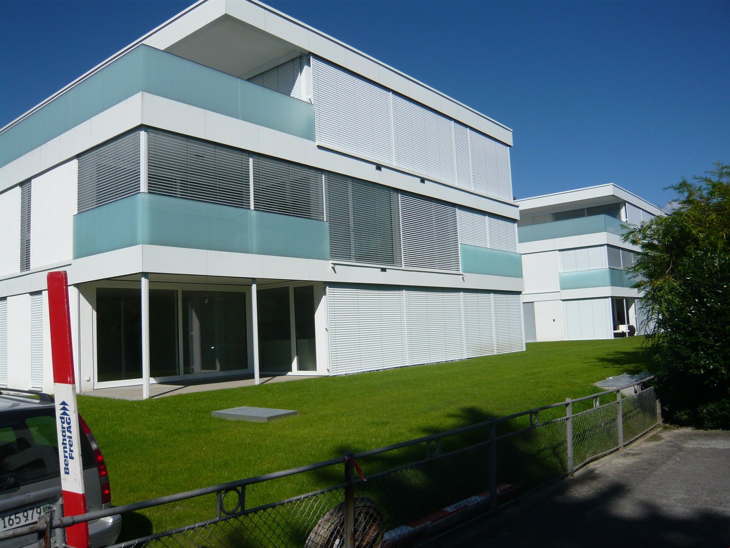 modern 2 story house, white facade, glass windows, balcony, lawn