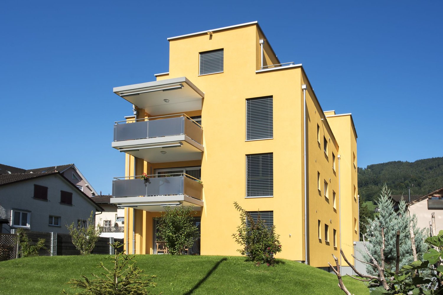 Yellow apartment building, 3 stories, balconies, mountain view