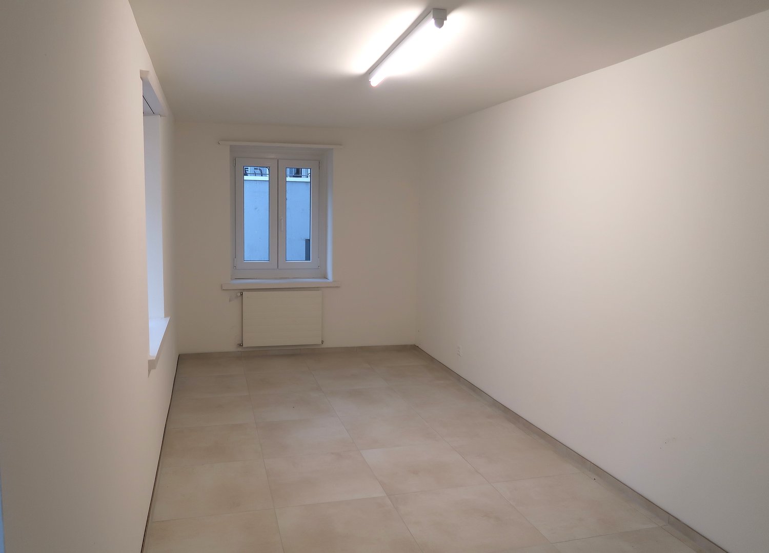 empty room, tiled floor, 2 windows, white walls, heater