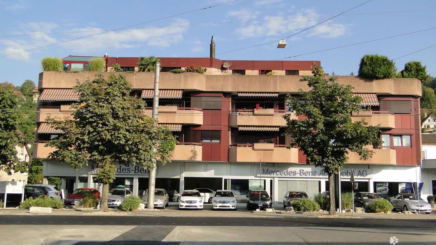 Multiple story building, cars parked in front of it