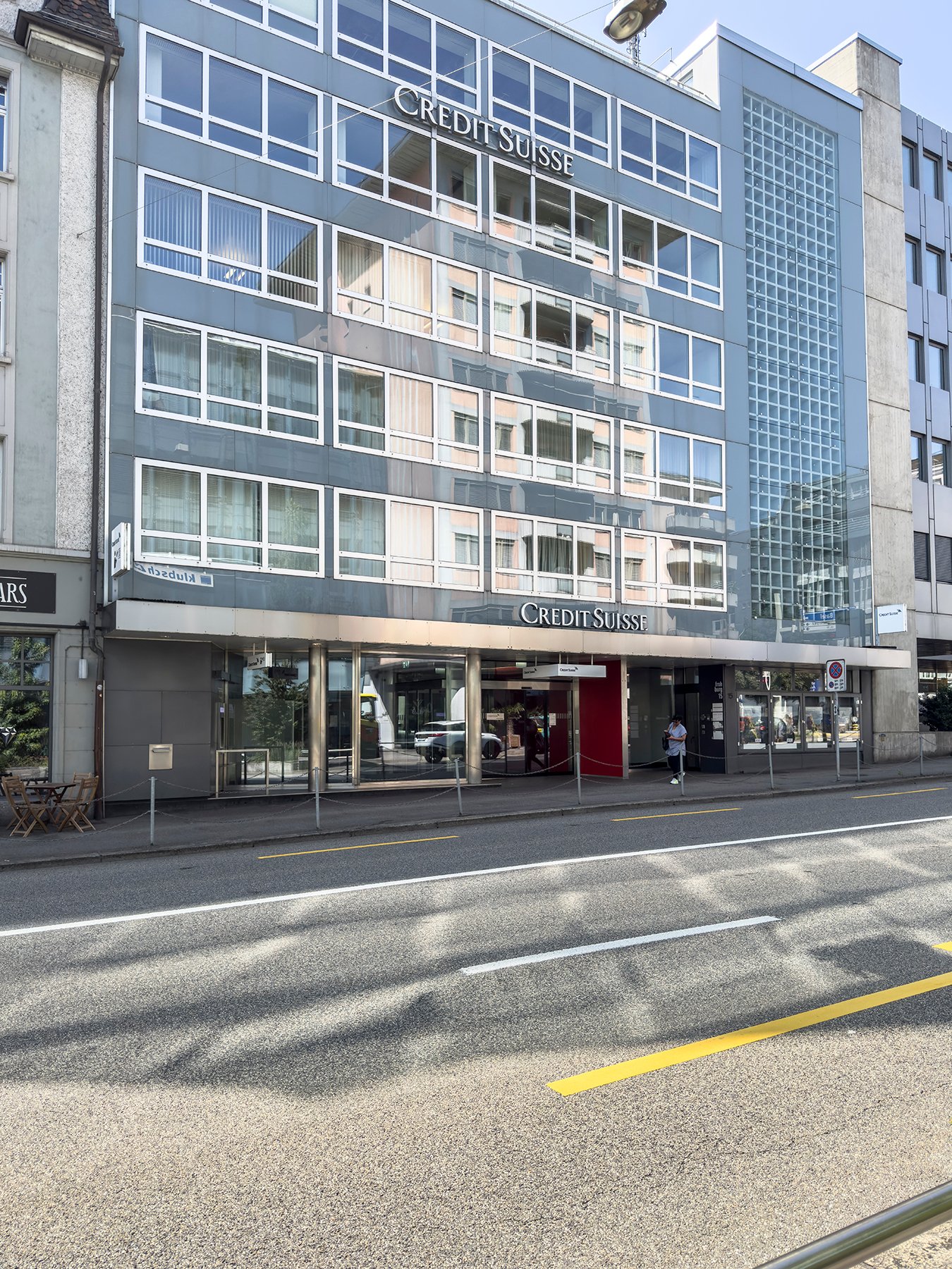 Credit Suisse bank, glass facade, multiple floors, glass windows, entrance, car parked outside
