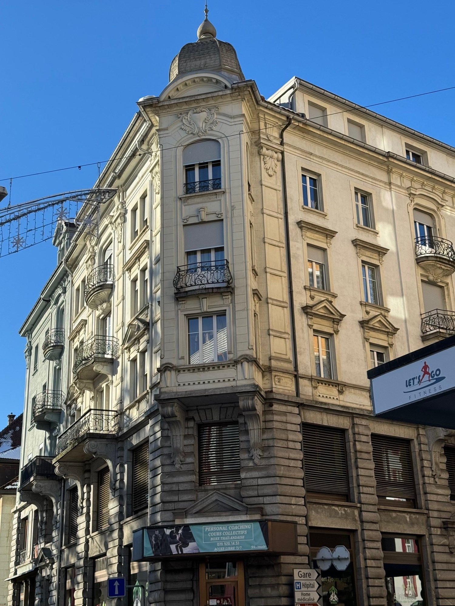Facade of a building, three floors, several balconies, windows with shutters