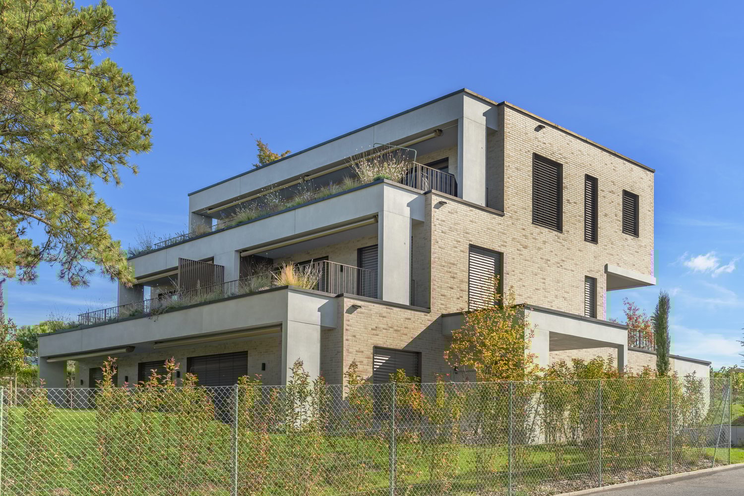 modern multistory house, brick facade, 2 garages, terraces on different levels