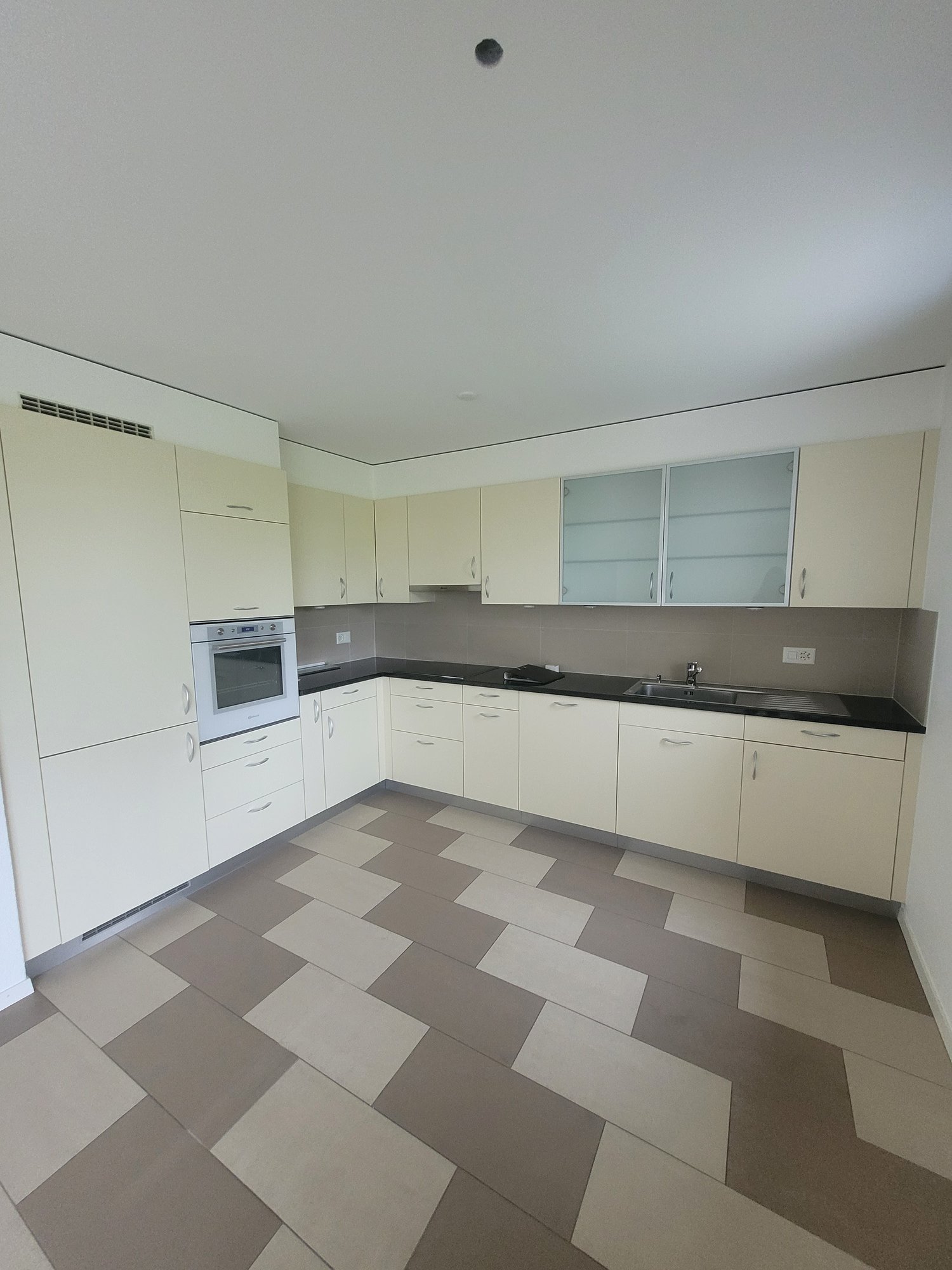 modern kitchen, tile floor, white cabinetry, built-in oven, stainless steel appliances