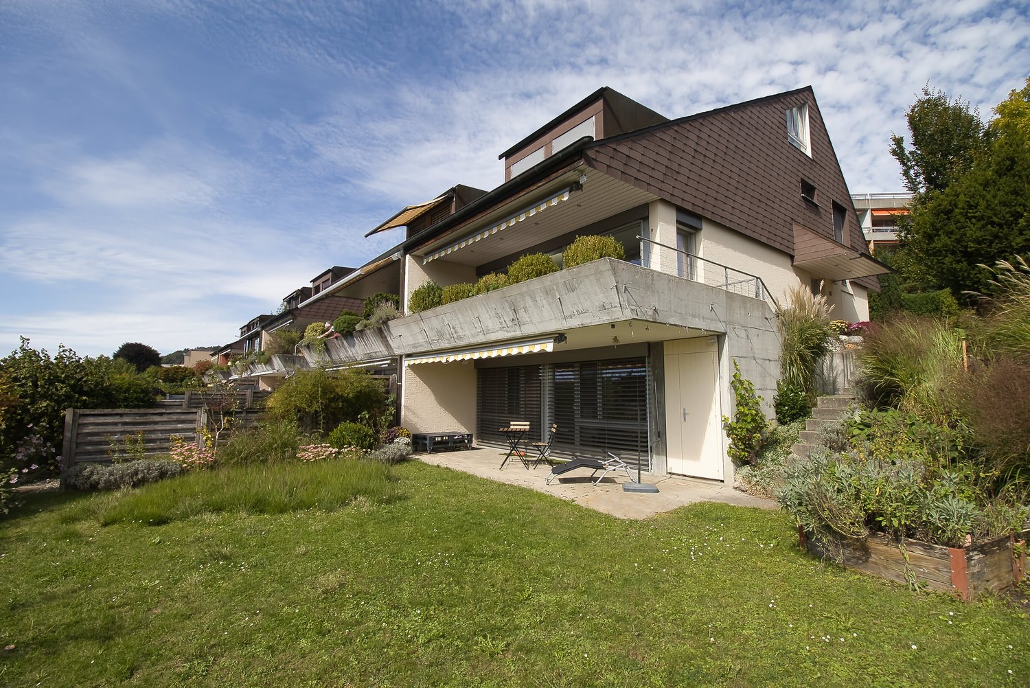 modern terraced house, raised ground floor, surrounded by greenery, view of surrounding area