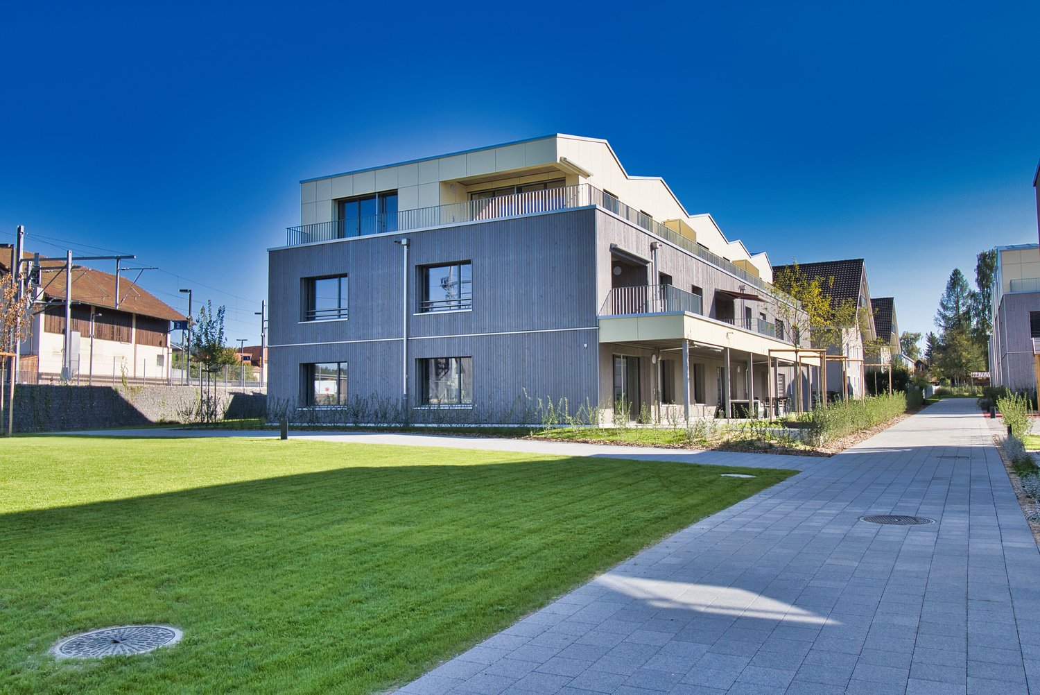 Modern apartment building with balconies, landscaped area