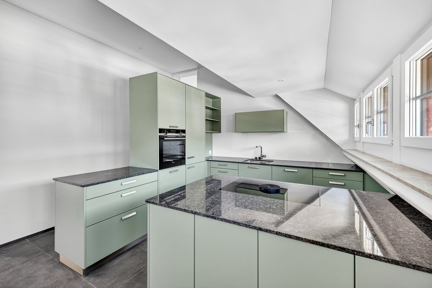 modern kitchen with green cabinets, granite countertops, built-in oven, sink, and faucet, large windows