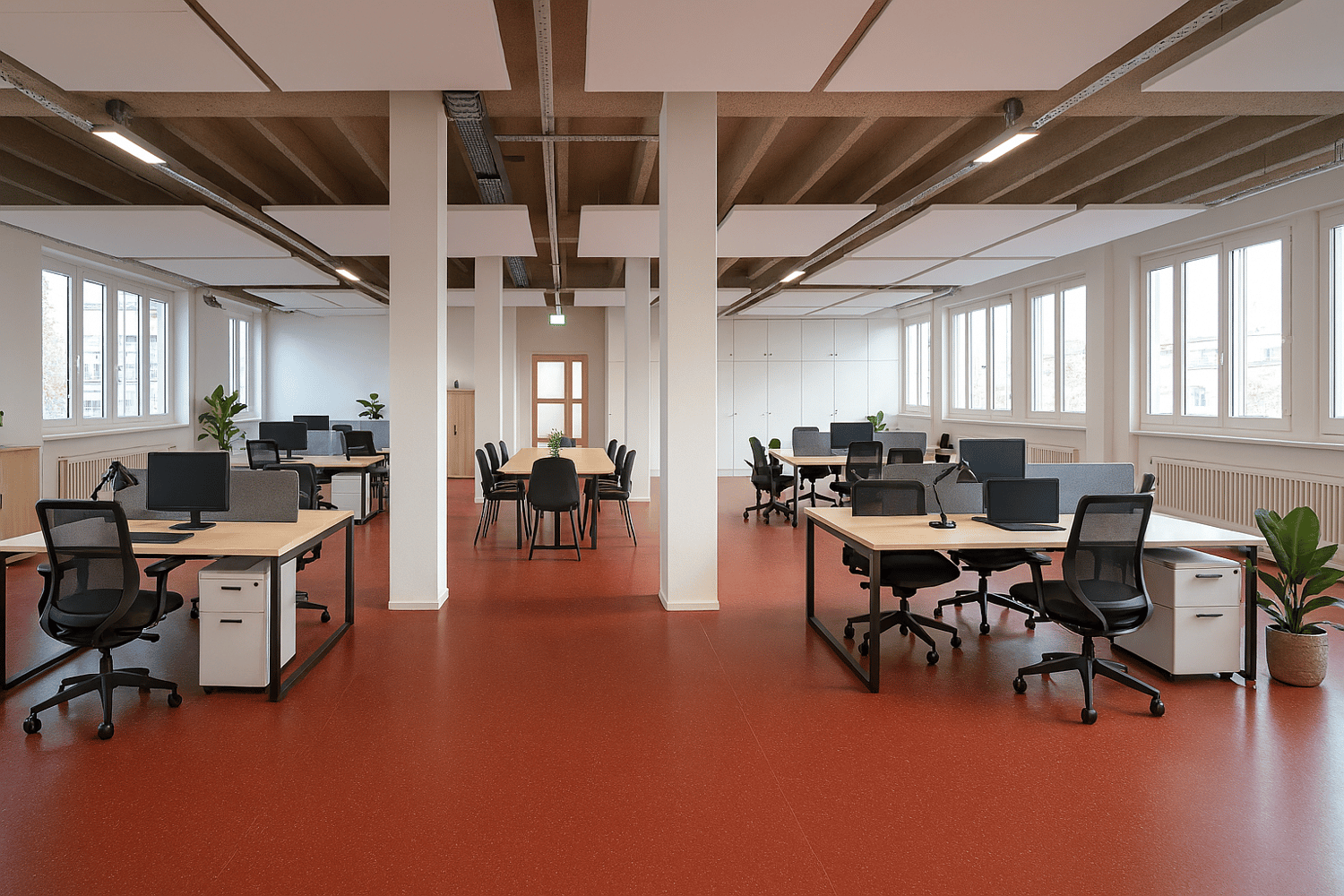 modern office space with desks, chairs, monitors, cabinets, radiators, plants, red floor, white walls, large windows