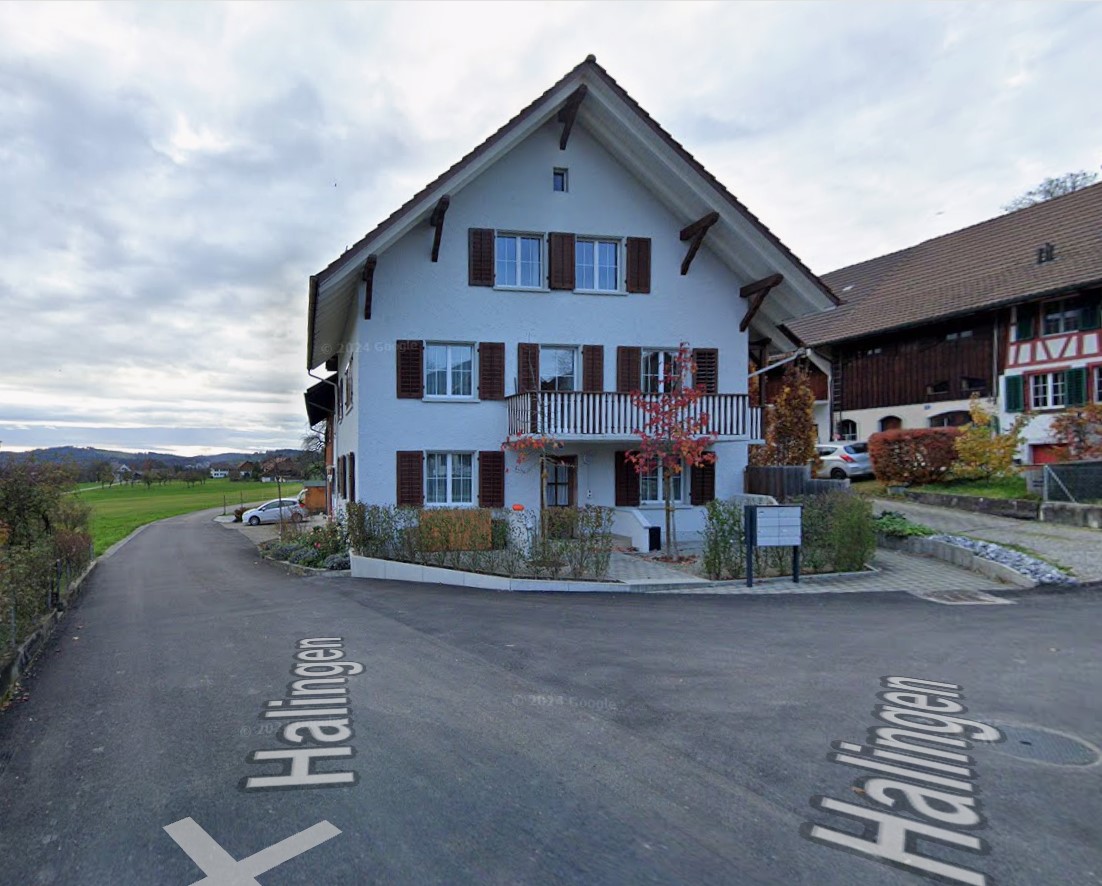 two story house, white exterior, brown shutters, small balcony, gravel driveway