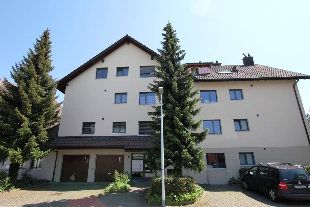 3 story house, beige exterior, multiple windows, garage, car parked in front
