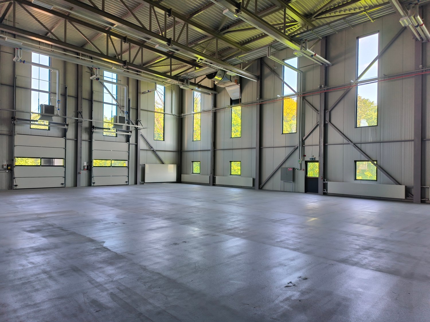 large open space, metal beams, large windows, concrete floor, industrial look