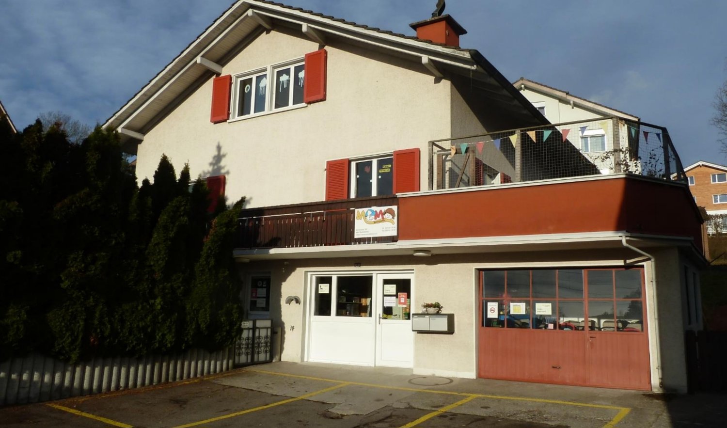 2 story building, red shutters, balcony with fence, garage, parking place, windows, door