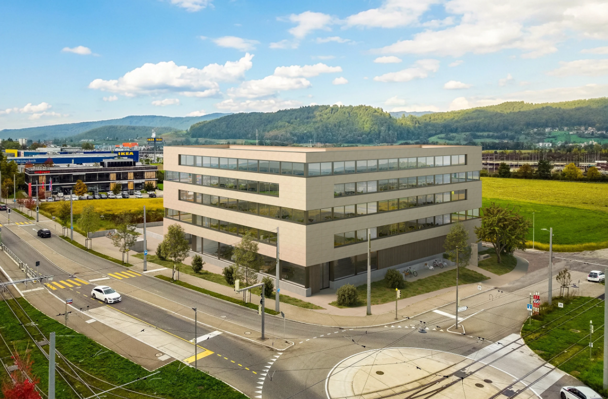Office building with multiple floors, glass windows, located near a road intersection, surrounded by greenery and mountains in the background.