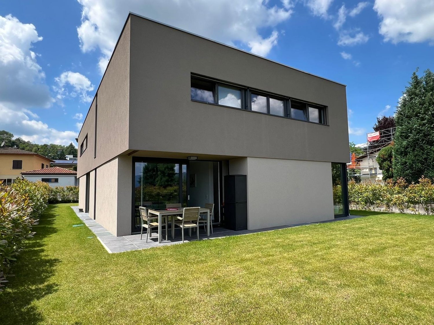 modern house, large windows, glass doors, outdoor dining table, backyard
