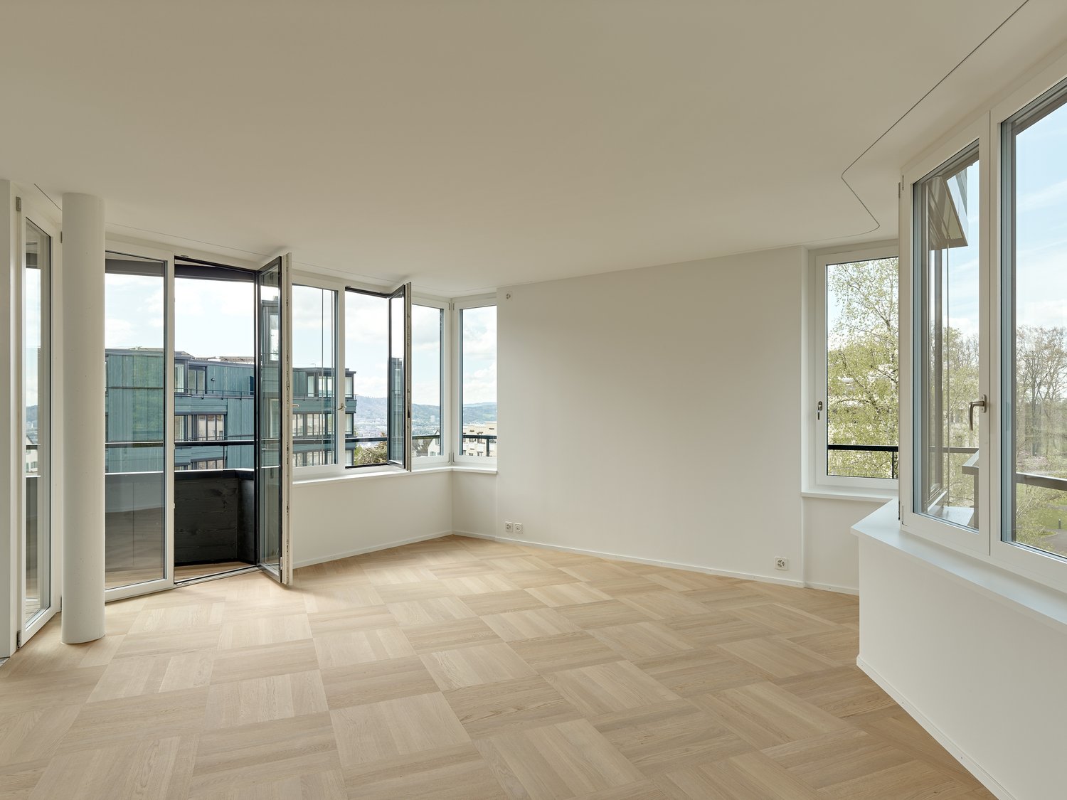 wide room, large windows, balcony, white walls, wooden floor
