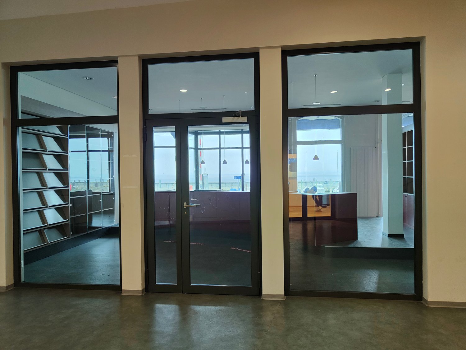 empty room, large glass windows, modern office furniture, neutral color scheme