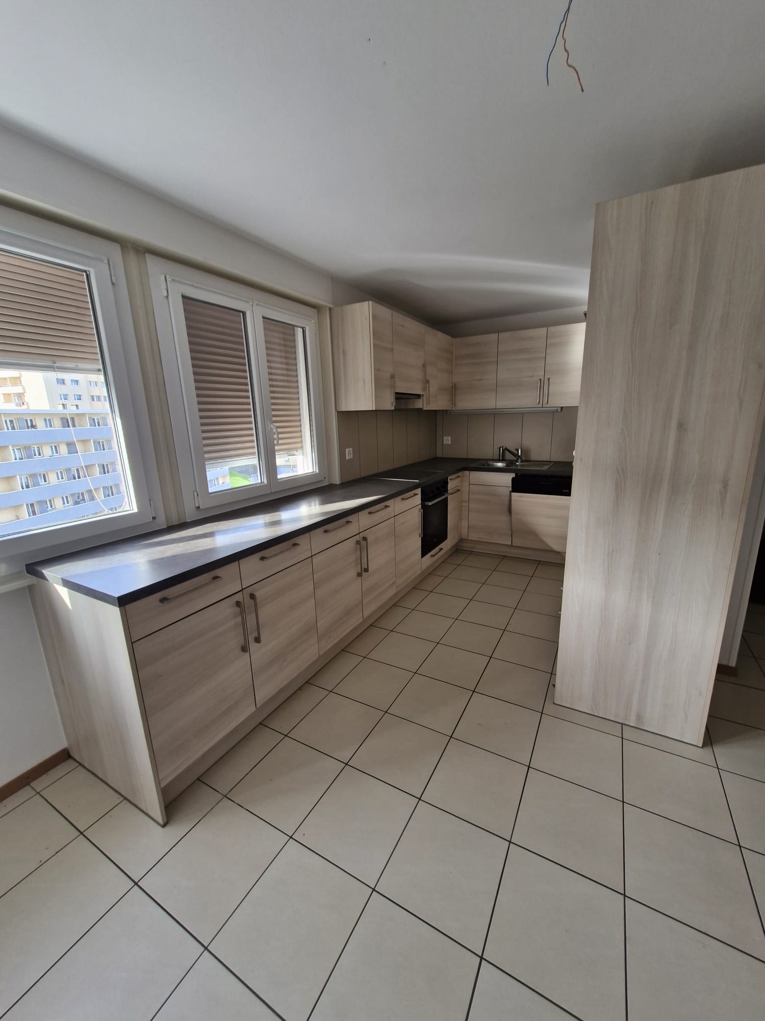 modern style kitchen with wooden cabinets, tile flooring, countertops, windows, kitchen appliances such as oven, sink, faucet