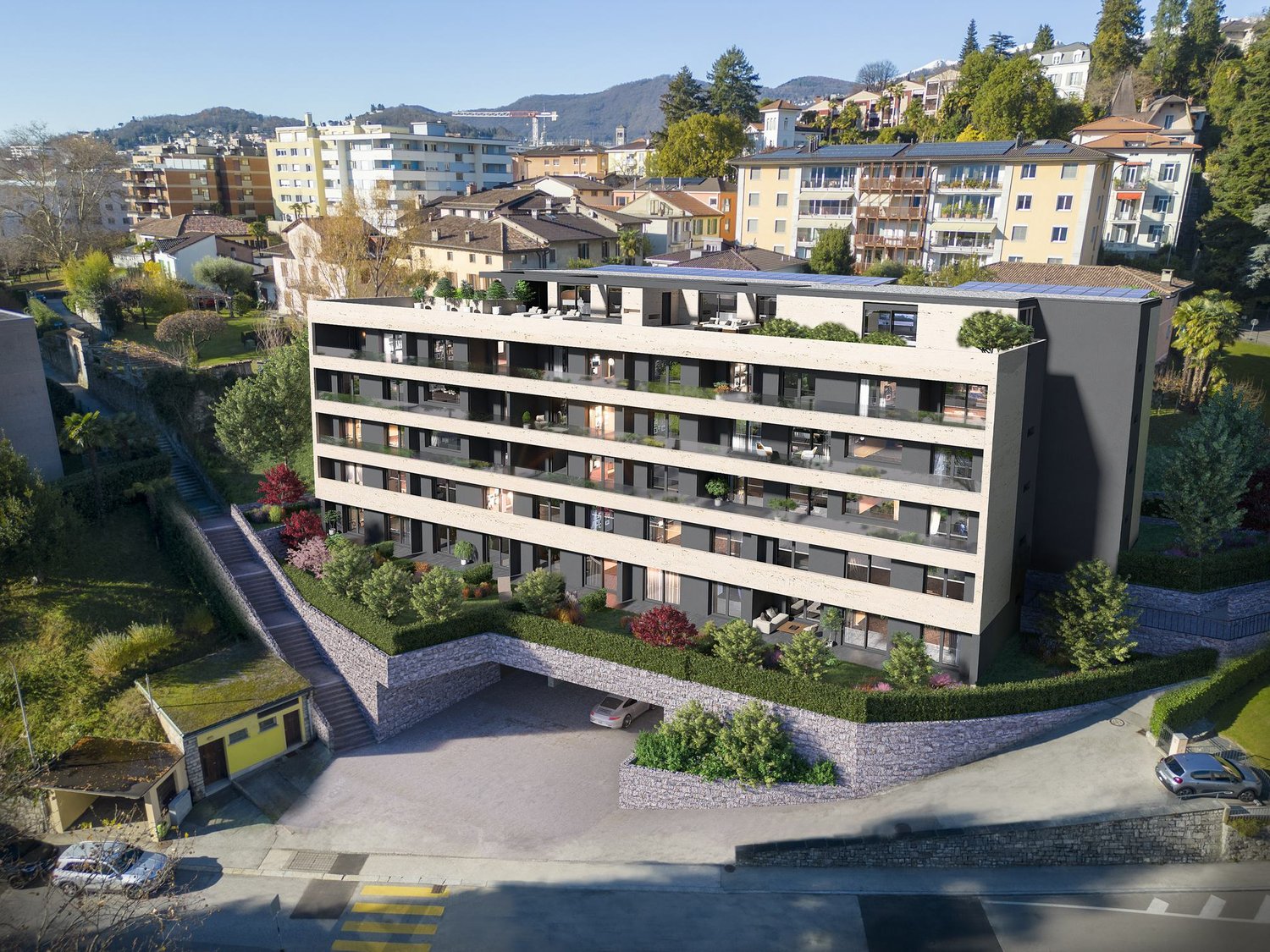 An aerial view of a new building with balconies, steps leading down to the entrance, and a garage.