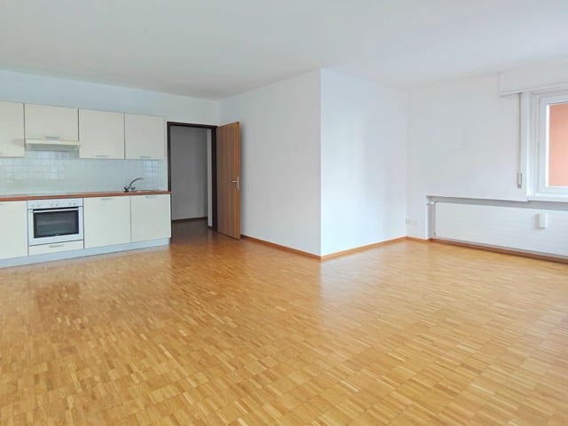 empty room, white walls, hardwood floors, white kitchen cabinets, sink, oven