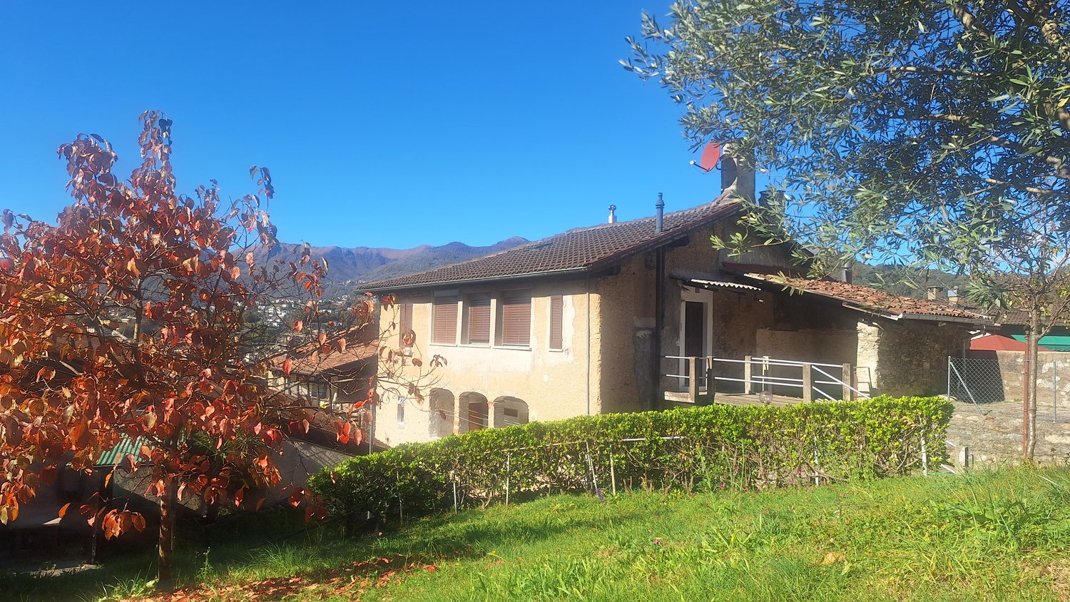 large stone house with a view of the mountains, arched windows, roof chimneys, greenery
