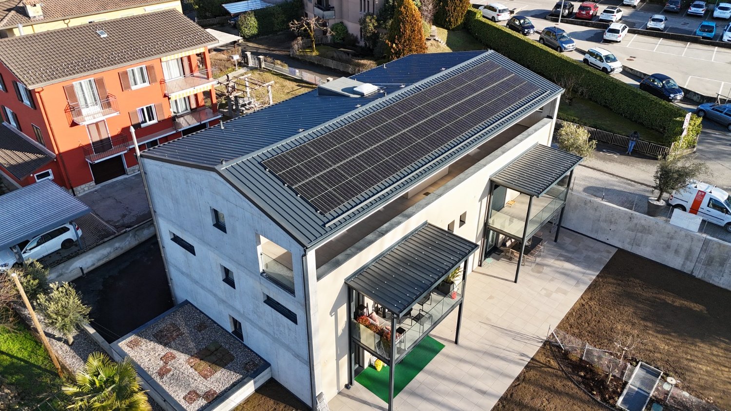House, blue roof, solar panels, 4 story, many cars parked