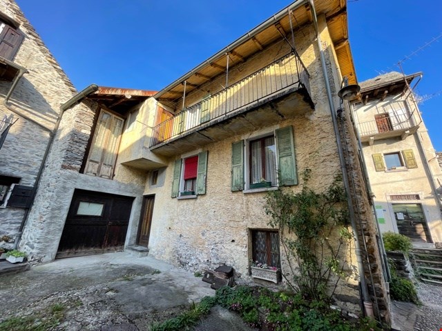 Two story house with stone wall, balcony, garage