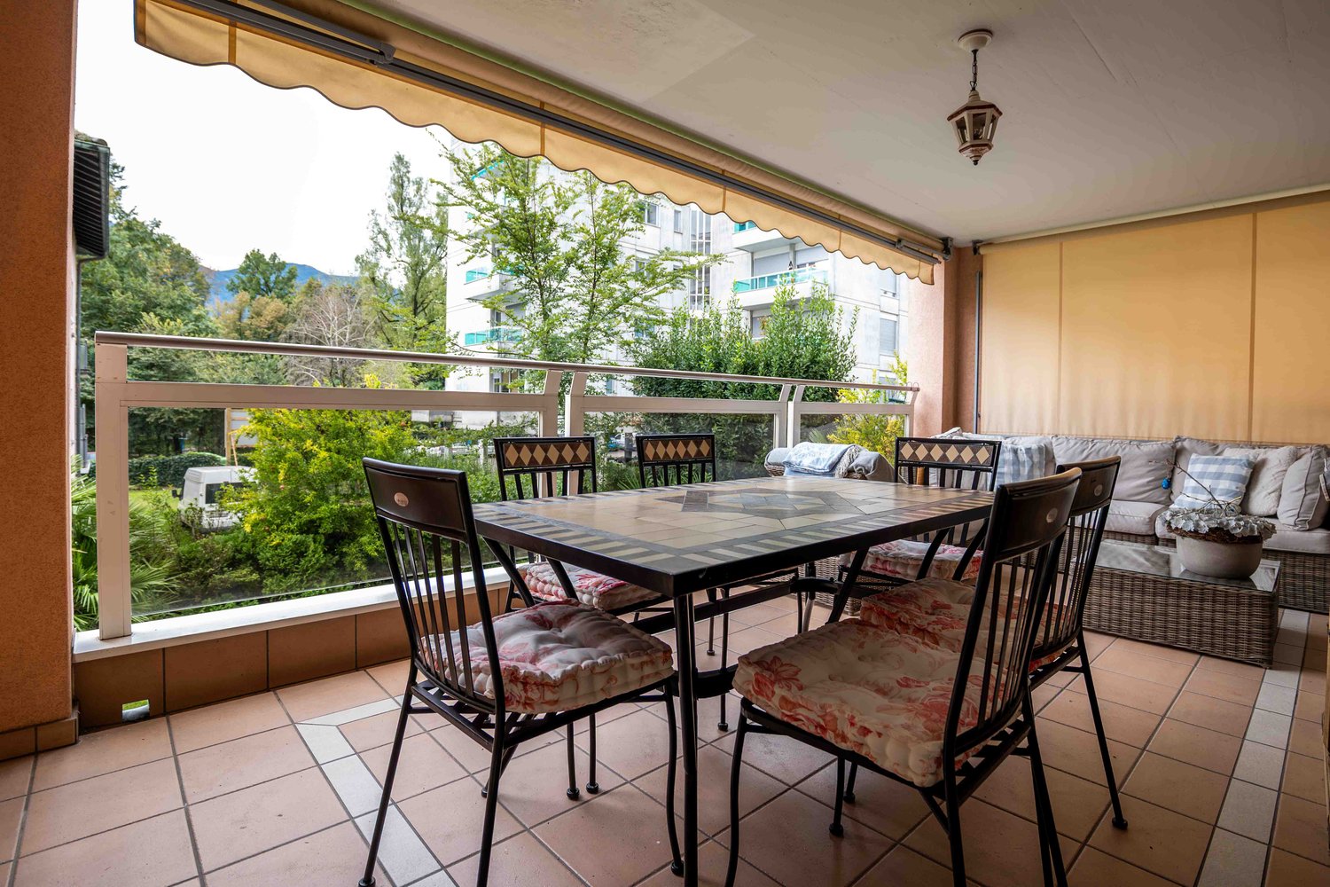 covered terrace with table and chairs, sofa, lamp