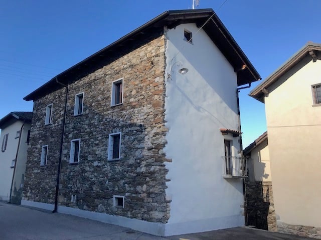 2 story house, stone exterior, white interior, multiple windows, balcony on second floor