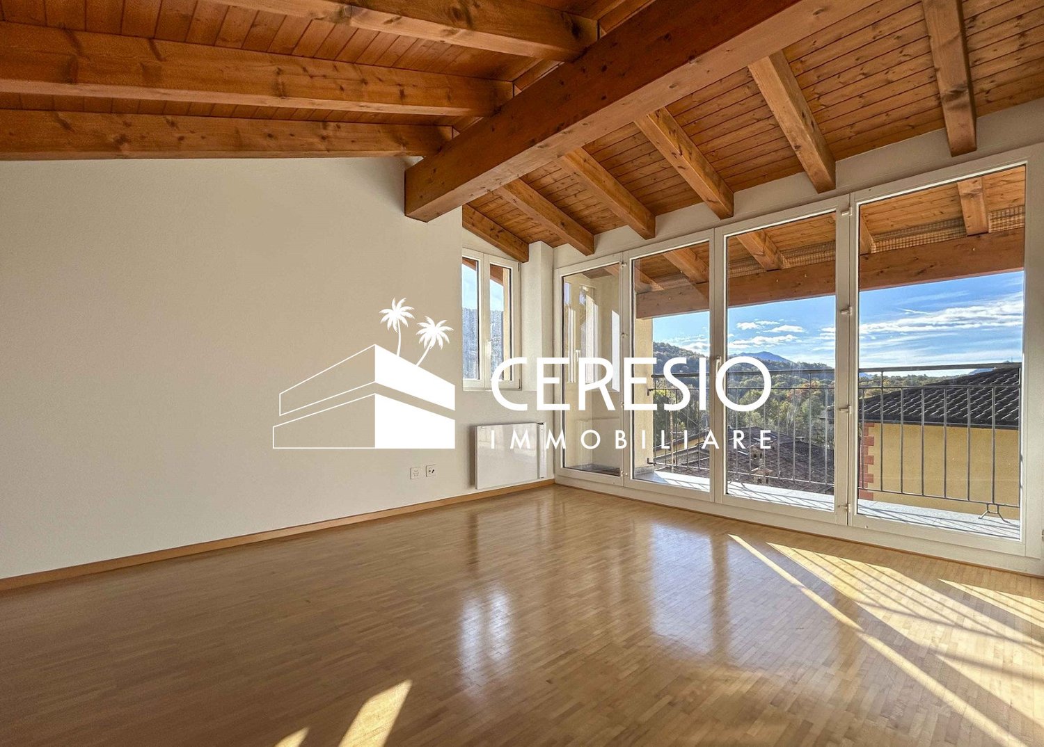 hardwood floors, white walls, large windows, balcony, high ceiling with wooden beams