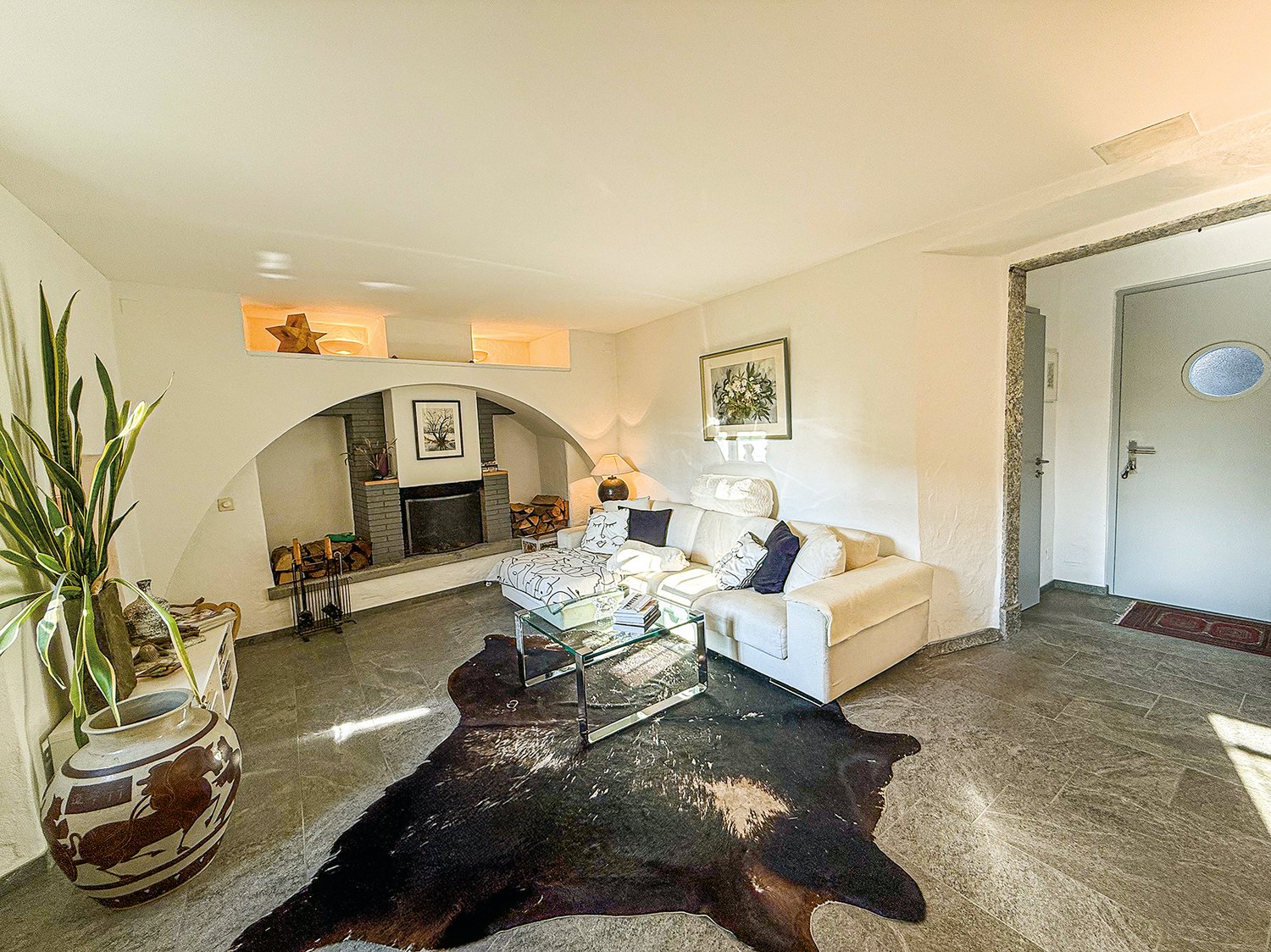 neutral color, couch, fireplace, coffee table, rug, indoor plant