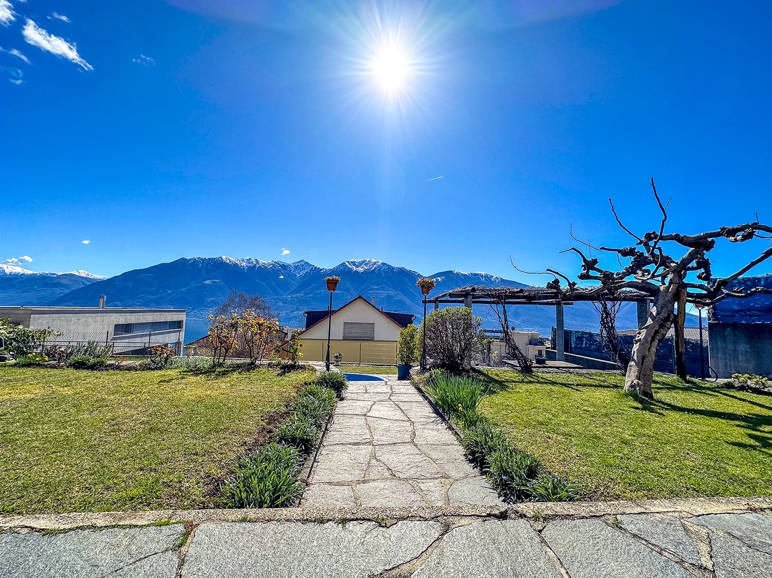 Stone walkway, grass, garden, trees, mountains in the background