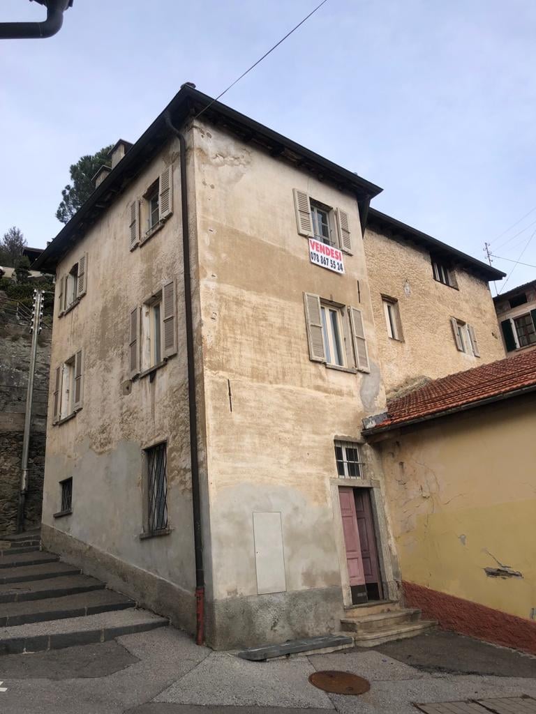4 story house, tan walls, white shutters, red door, stairs