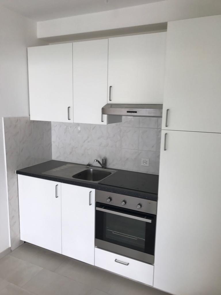 white cabinets, black countertop, stainless steel sink, stainless steel oven and stove, exhaust hood
